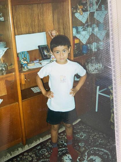 Mert as a child, hands on his hips